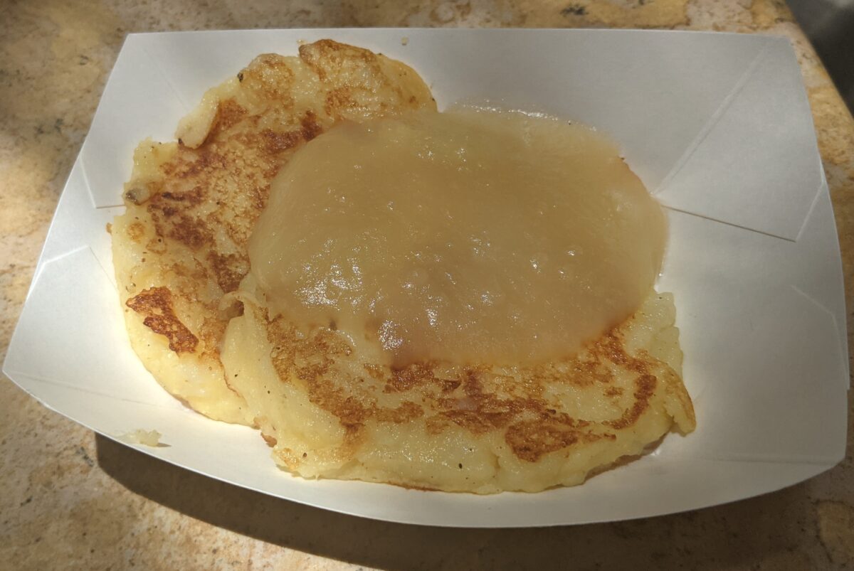 The outdoor kitchens at Taste of Epcot International Flower & Garden Festival at Disney World in Orlando, Florida has delicious food like this potato pancakes with applesauce