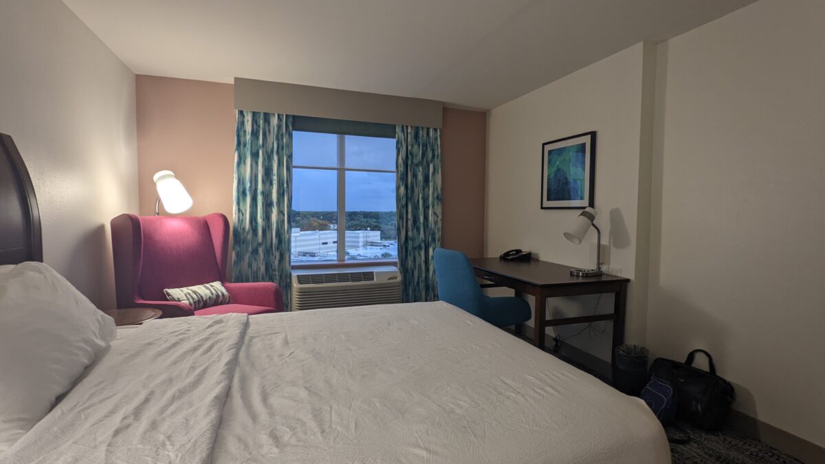 A picture of the bed and desk at a guest room at Hilton Garden Inn at SeaWorld Orlando.