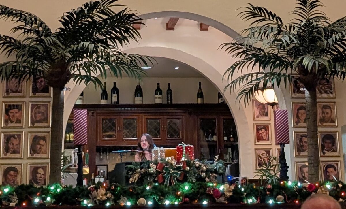A picture of a live piano and singing performance at Jazzy Holidays at Disney's Hollywood Brown Derby during Jollywood Nights, a Christmastime event.
